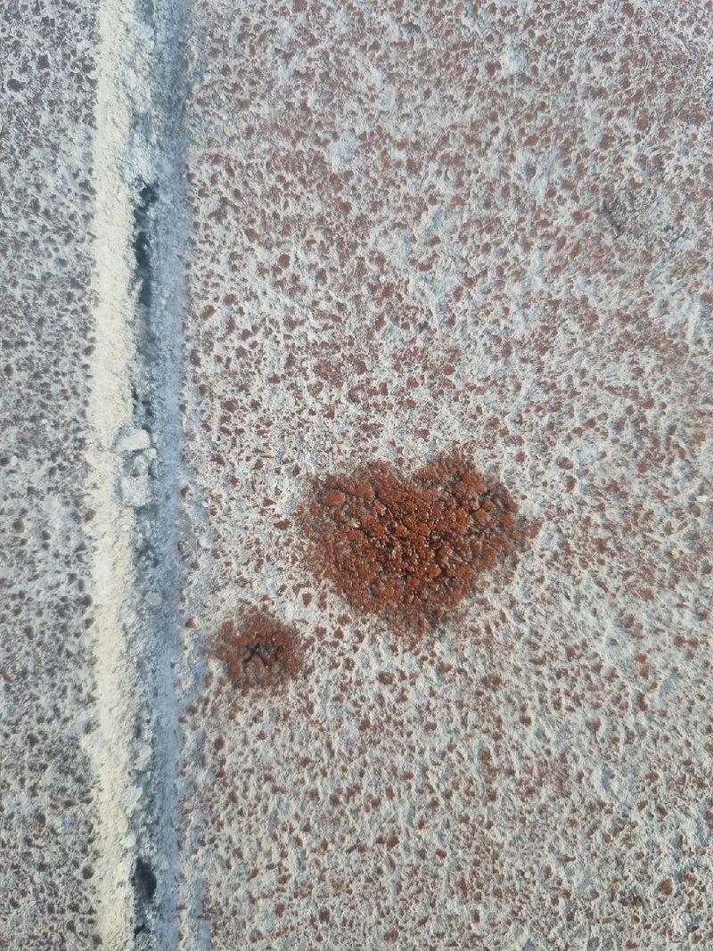 A water drop in the shape of a heart on a frosty sidewalk